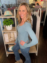 Woman standing in a store wearing a blue shirt and blue jeans.
