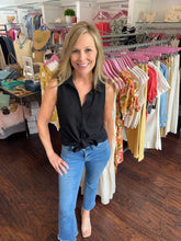 Woman in a clothing store wearing a black top.