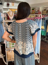 Woman wearing a patterned top in a clothing store