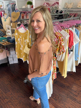 Woman standing in a clothing store with racks of clothes in the background