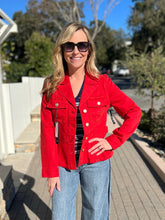 Woman wearing a red peplum jacket and sunglasses outdoors on a sunny day.
