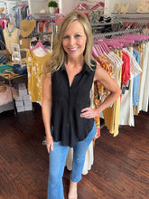 Woman in a clothing store wearing a black top.