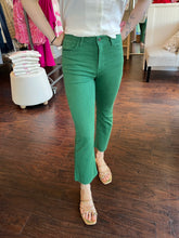 Woman wearing green jeans standing in a store.