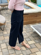 Person wearing a pink top and black pants on a patio with a fire pit in the background