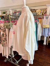 White open back sweatshirt on a mannequin in a clothing store setting