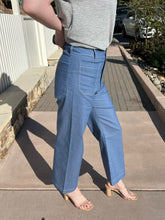 Person wearing blue wide  pants on a concrete surface.
