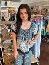 Woman wearing a patterned top and pants in a clothing store