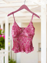 Pink patterned tank top on a hanger.