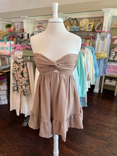 Mannequin wearing a beige dress with a blurred store background