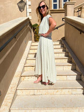 Woman in a striped dress standing on stone steps outdoors.