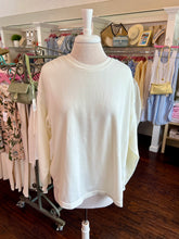 White open back sweatshirt on a mannequin in a clothing store setting