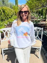 Woman wearing a white sweatshirt with a graphic design outdoors