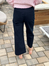 Person wearing navy pants and a pink top on a paved outdoor patio.