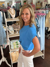 Woman in a blue shirt standing in a clothing store