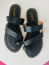 Black sandals with multiple straps on a white background