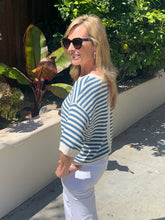 Woman wearing a striped sweater and sunglasses outdoors