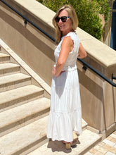 Woman in a white dress standing on steps outdoors