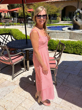 Woman in a red and white striped dress standing outdoors on a patio.
