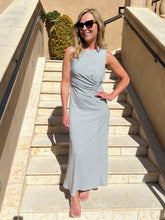 Woman in a patterned dress standing on stone steps outdoors