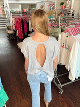 Person wearing a sleeveless top and jeans in a store setting