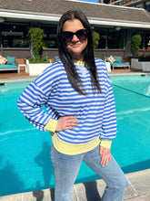 Woman in a blue and white striped shirt by a pool