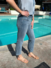 Person wearing blue jeans standing by a pool