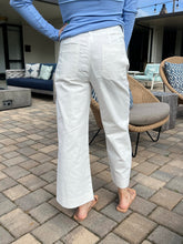 Person wearing white pants and a blue top on a patio