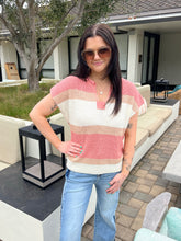 Woman wearing a striped sweater and sunglasses outdoors