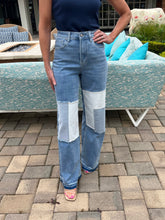 Person wearing patchwork jeans standing on a patio