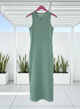 Green and white striped dress on a hanger with plants in the background