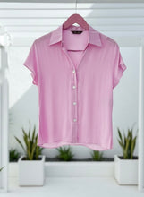 Lilac shirt on a hanger with a blurred indoor background