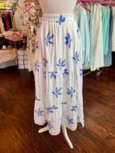 White skirt with blue floral patterns on a mannequin in a store setting.