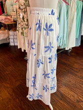 White skirt with blue floral patterns on a mannequin in a store setting.