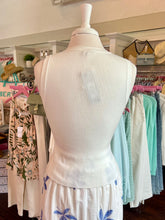 Mannequin wearing a white top with floral skirt in a store setting