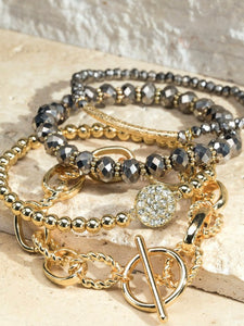 Set of 4 assorted gold and grey bracelets.
