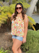 Women posing wearing yellow floral tank top showing front view, 