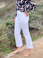 Close up of women wearing white jeans, showing side detailing.
